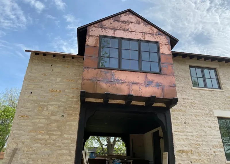 Copper metal panel facade on a stone building for Roof Repair in Almena